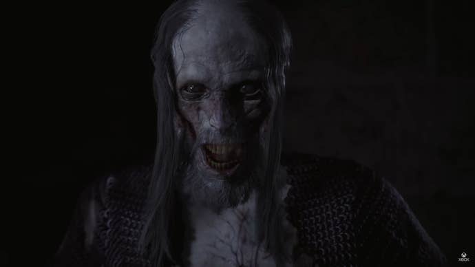 A vampire breathes mist astatine the camera, with a rotting face.