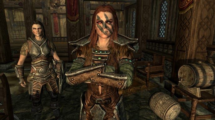 Talking with Aela the Huntress while Lydia watches in a The Elder Scrolls V: Skyrim screenshot.