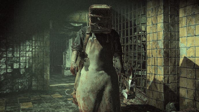 A screenshot from The Evil Within showing an aproned man with a barbed-wire-wrapped safe for a head standing in a filthy tiled corridor.