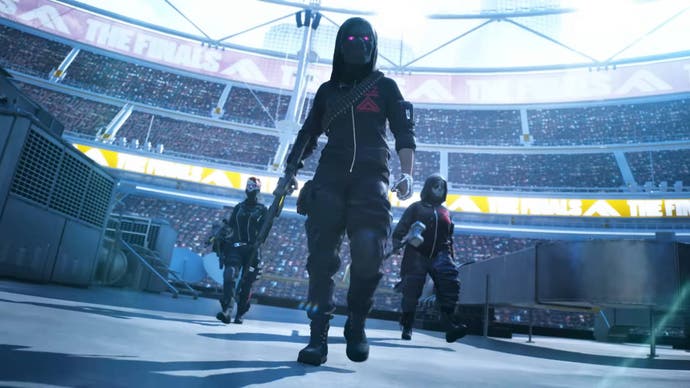 Three The Finals characters in black hooded jumpers walking towards the camera in a stadium with the crowd behind them.