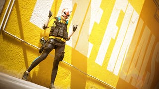 Promo image for The Finals showing a player character in a cat-like mask doing the double 'finger guns' pose against a yellow background