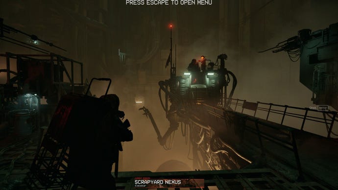 A control room hangs suspended above a huge drop, with a short metal bridge leading to it.