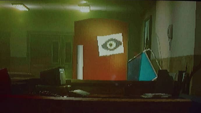 A red fridge with an A4 paper with an eye drawn on it stuck on the door, standing in what appears to be a hospital waiting room