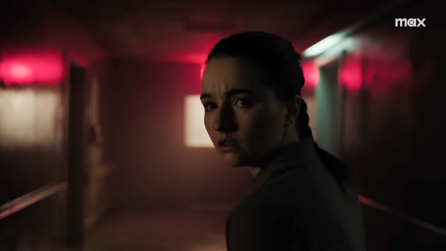 Abby looking concerned in a dimly lit hospital corridor in The Last of Us season 2. - 1