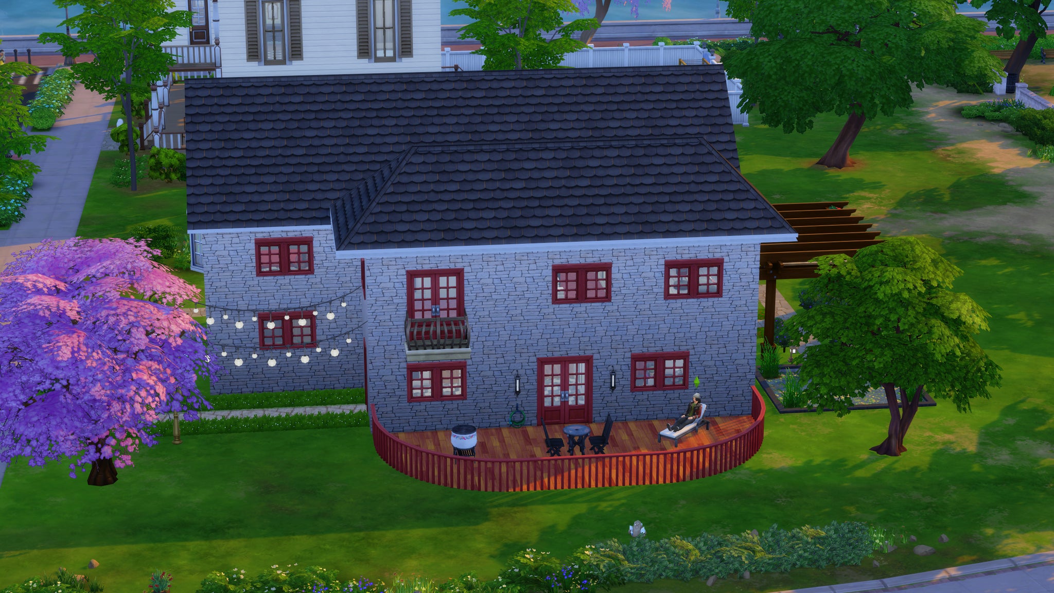 A custom house in The Sims 4 with a sim sitting outside it. - 4