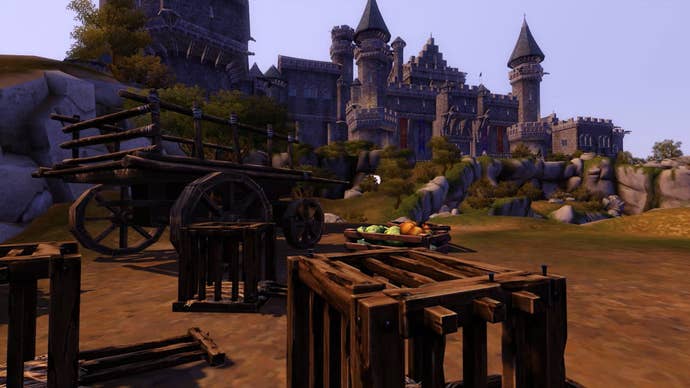 Wooden crates and a wagon litter the foreground, while in the background a medieval castle dominates the skyline of The Sims Medieval.