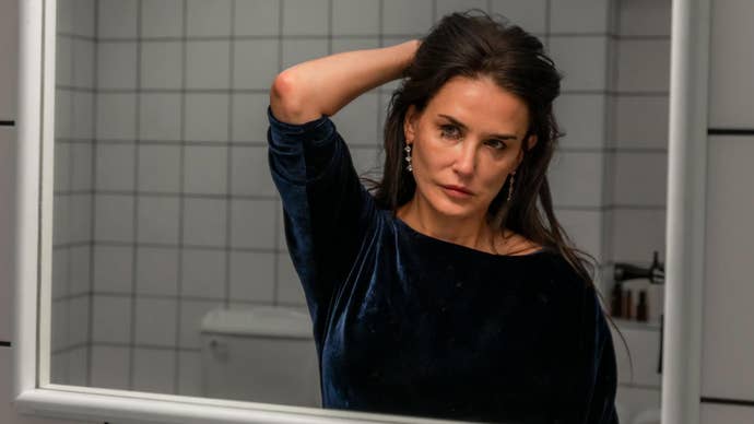 Demi Moore looking at herself in a mirror, make-up smudged in The Substance.