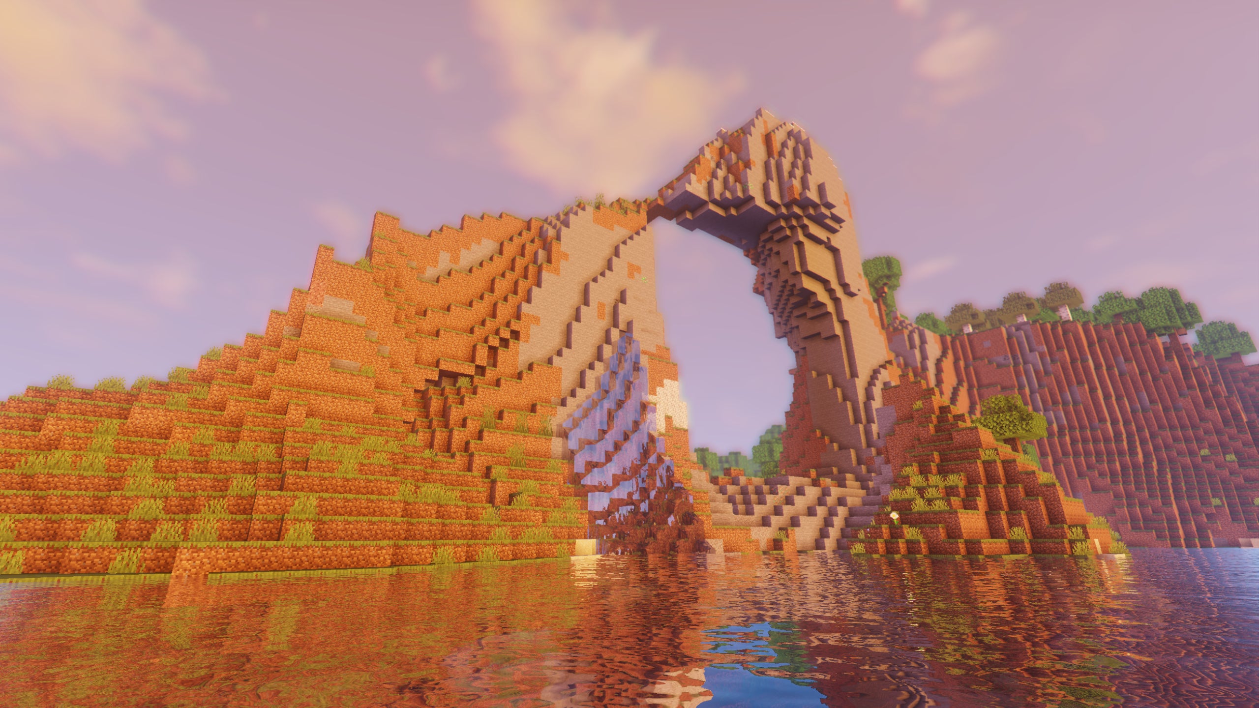 An archway through a cliff in the middle of a lake in Minecraft with TME Shaders installed.