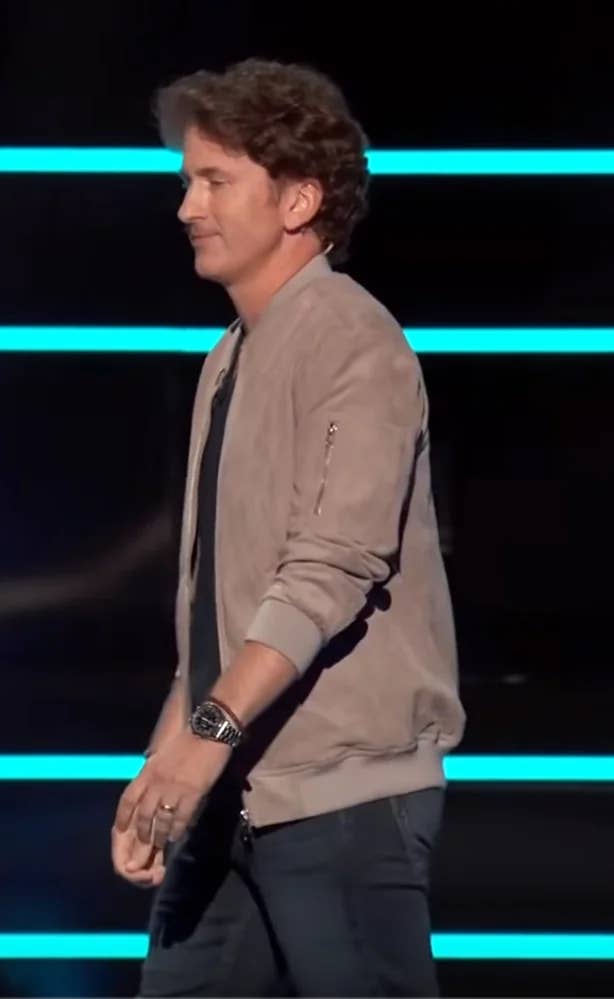 Todd Howard on-stage during the Starfield release date reveal, wearing a Speedmaster watch on his left wrist