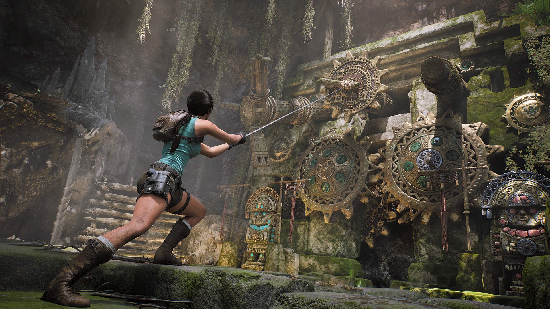 A lady in leather boots, tiny brown shorts, and a tight green vest, pulls a rope attached to a series of large cogs in a temple of some kind.