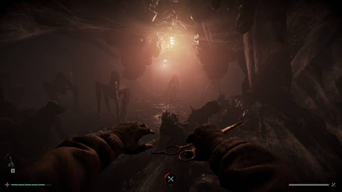 A screenshot from Total Chaos showing a dark, basement like area lit by candlelight and populated with spider-like but alien-looking creatures. In the nearground we see a characters hands and in one of them is a pair of scissors, held as if to attack with them.