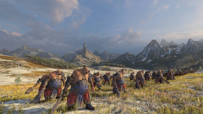 A line of fearsome ogres in Total War: Warhammer 3 standing ready on the battlefield