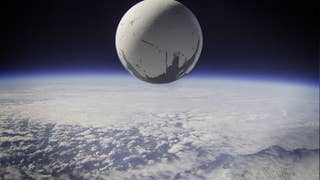 A Destiny 2 image showing the enormous spherical Traveler hovering above the Earth's orbit.