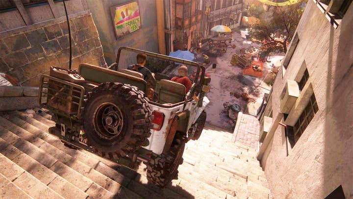 An Uncharted 4 screen showing the player in a jeep careening down a set of stairs toward an area with people running for cover