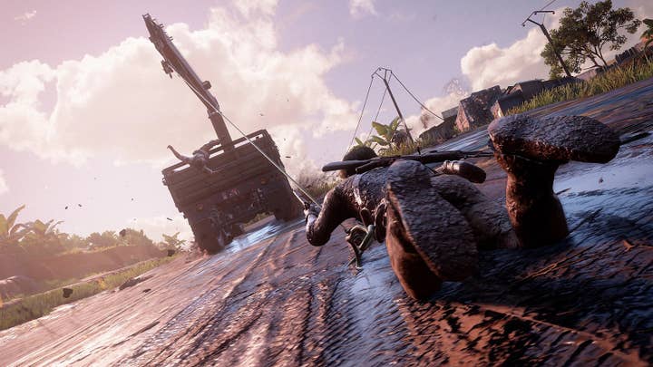 Uncharted 4 screenshot showing a character covered in mud, being dragged by a truck as another character falls off the back of the truck.