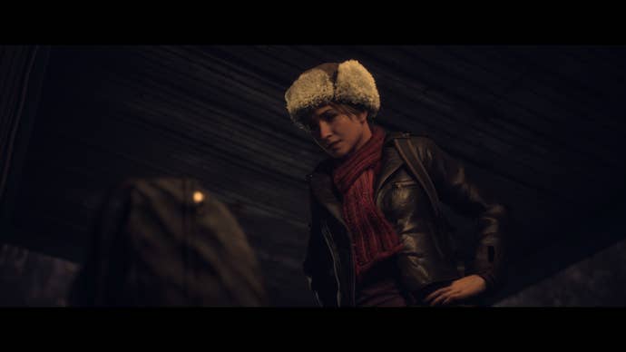 Sam leans over to examine Chris's bag at the cable car station.