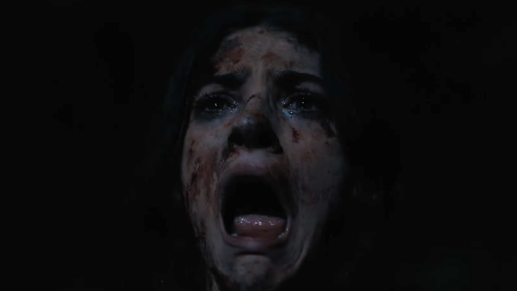 A close-up of a woman covered in dirt and blood in the Until Dawn movie, she is screaming. - 1