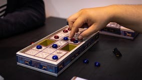Someone playing the updated version of an ancient board game, Ur: The Royal Game