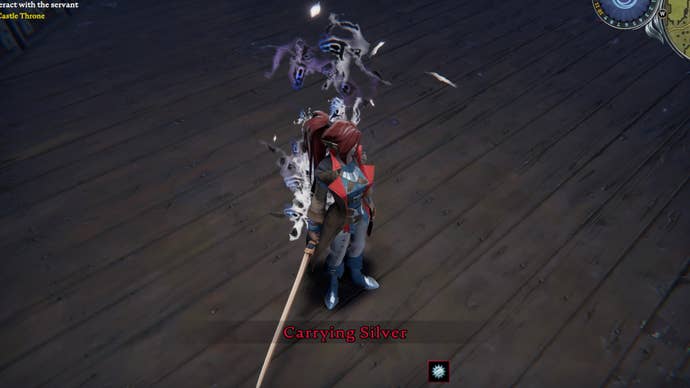 The player in V Rising stands on the wooden floor of their castle. They are taking damage due to carrying Silver.