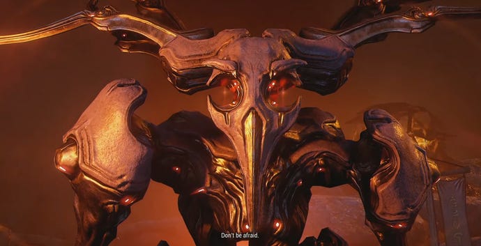 A screenshot of Warframe showing a terrible giant. The subtitle reads, “Don’t be afraid."