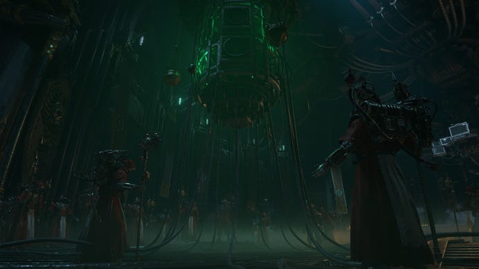 The priestly worshipers of 40K raise their arms to a machine in the centre of a room.