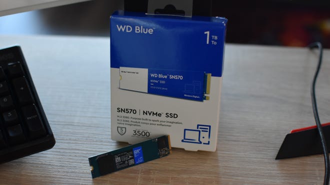 The WD Blue SN570 SSD next to its packaging box.