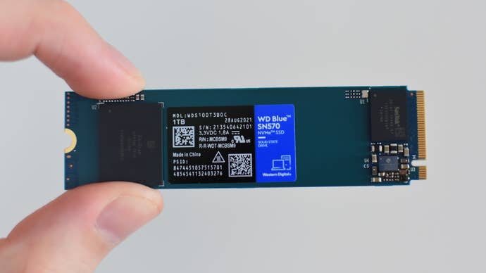 The WD Blue SN570 SSD being pinched between a thumb and finger.