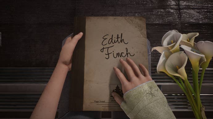 A hand touches Edith Finch’s journal in a What Remains of Edith Finch screenshot.