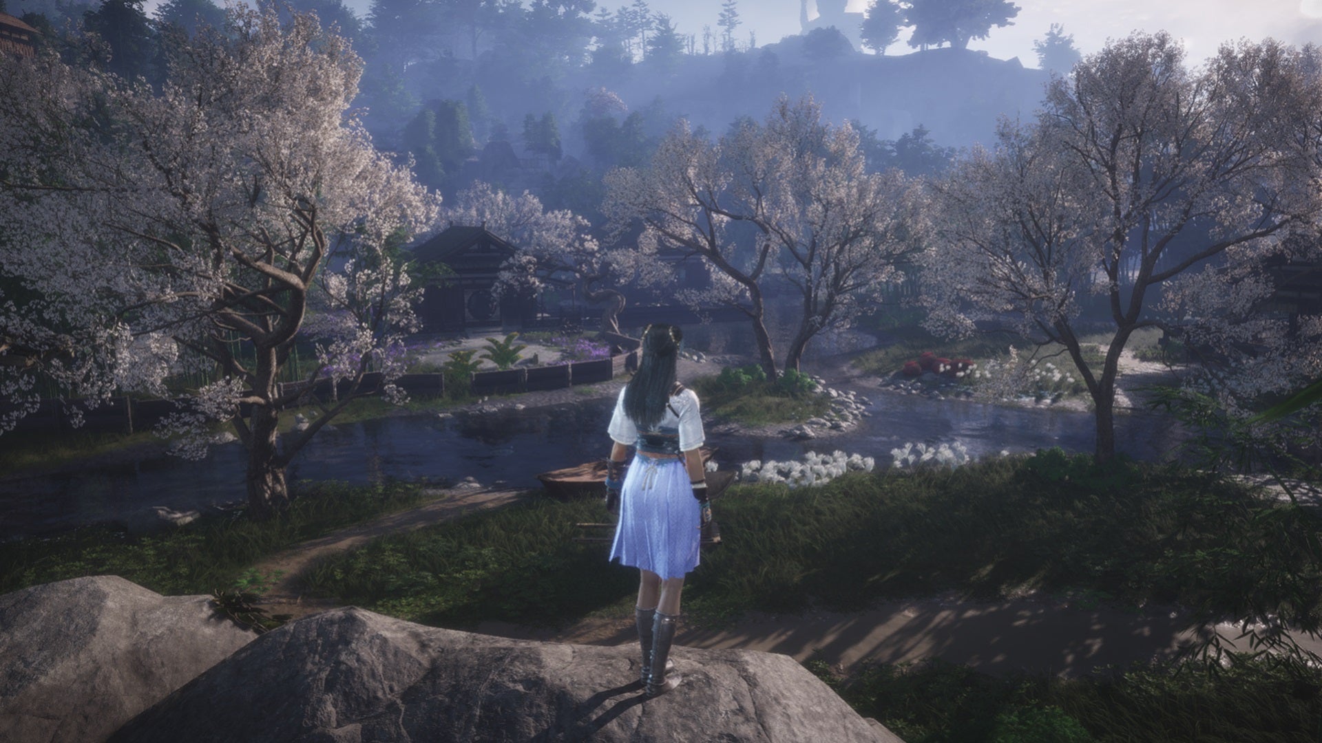 A female character in Where Winds Meet stands on a rocky outcropping, looking down at the forested river beneath her. - 1