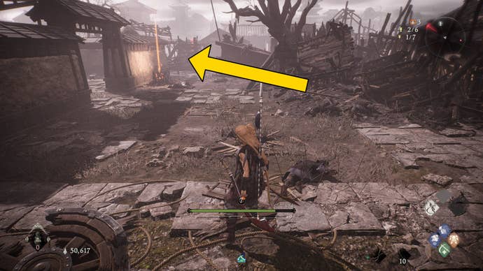 The player in Wo Long stands in front of a Battle Flag on the outskirts of a courtyard.