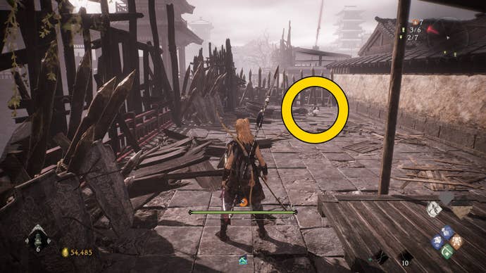 The player in Wo Long looks down towards a dead end surrounded by ruins and rubble. At the end of the dead end is a Shitieshou.