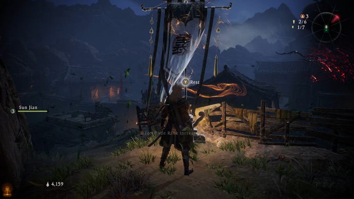 A Wo Long: Fallen Dynasty screenshot of the player standing next to a flag.