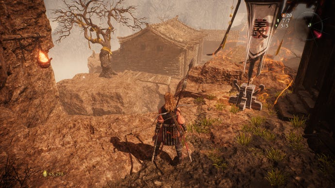 A Wo Long: Fallen Dynasty screenshot of the player standing next to a flag.