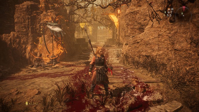 A Wo Long: Fallen Dynasty screenshot of the player standing next to a flag.