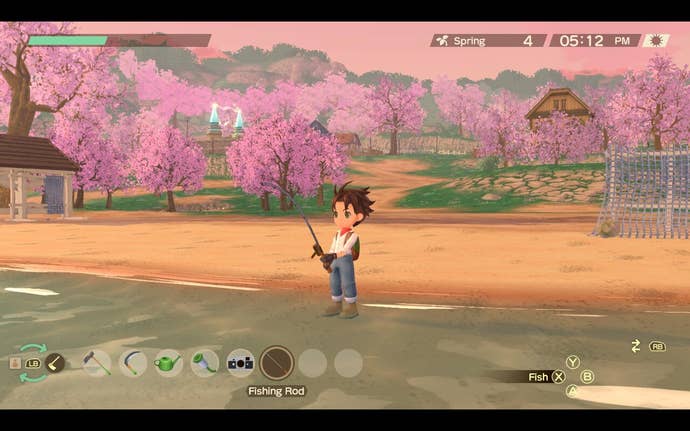 A farmer fishes in the ocean in front of cherry blossom