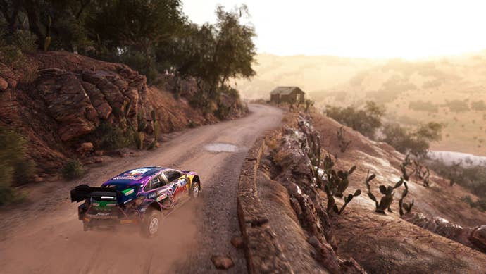 A rally car speeds done the ungraded of a hillside overlooking a valley.