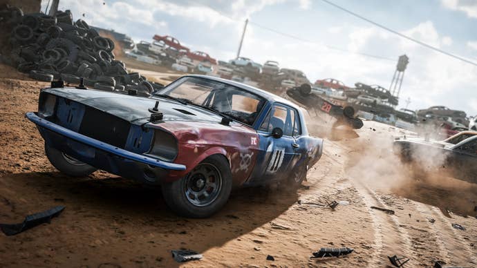 A car skids in a car yard full of broken old vehicles.