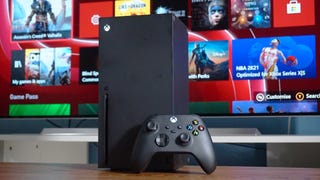 A photo of a black Xbox Series X and controller in front of a TV.
