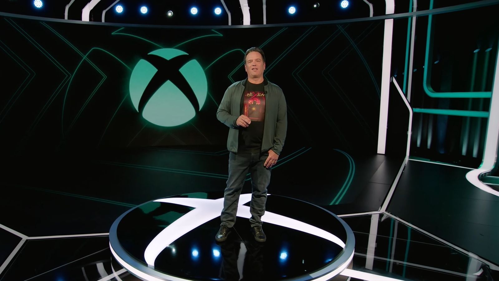 Phil Spencer, in trademark suit jacket with jeans and a logo tee combo, standing on stage at the 2023 Xbox Games Showcase - 1