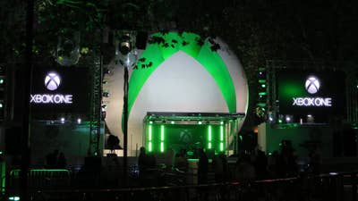 A stage set up for the Xbox One launch, with a gigantic Xbox logo sphere behind the stage and large video screens with the Xbox One logo on either side