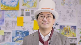 Yuji Naka in a white top hat in front of a board of designs