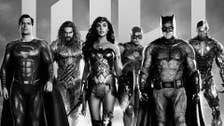 A poster of Zack Snyder's Justice League showing Superman, Aquaman, Wonder Woman, The Flash, Batman, and Cyborg all stood in a row in black and white.