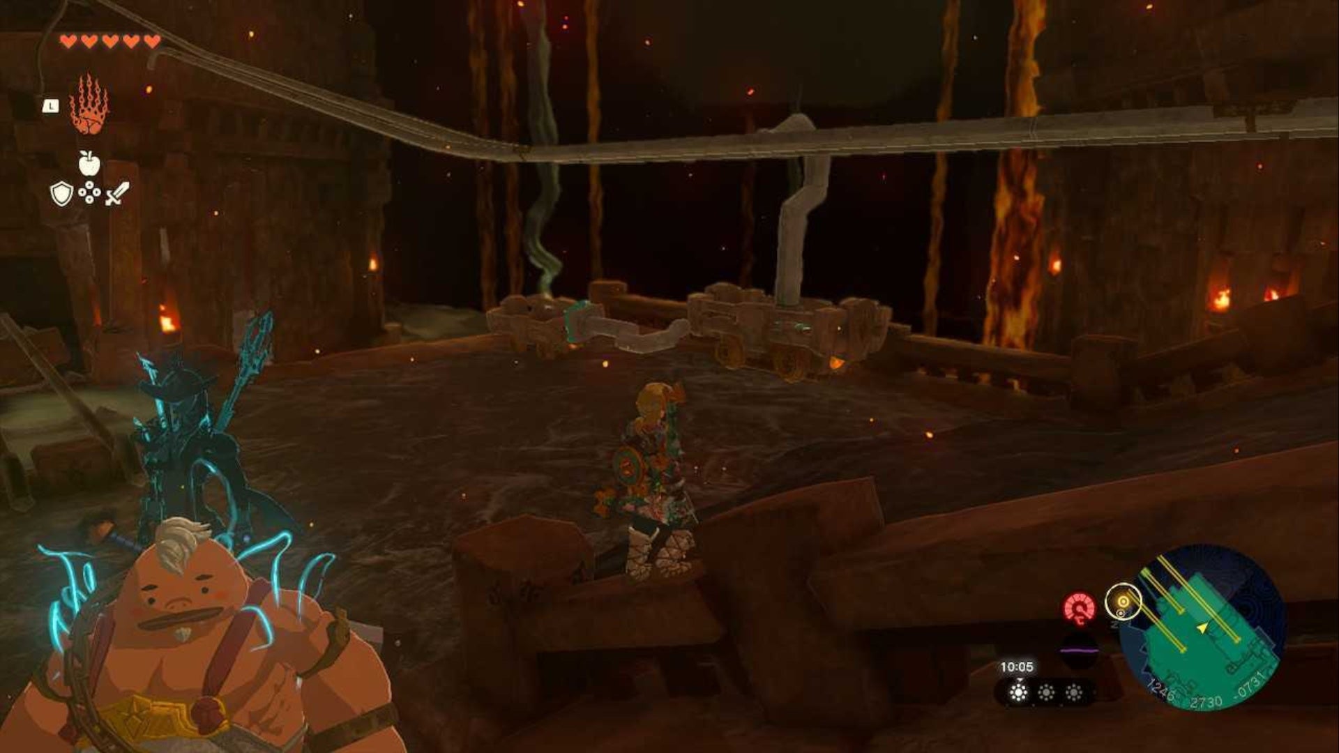 Zelda TOTK, Link and Yunobo are looking at a cart with a hook on it in the Fire Temple.