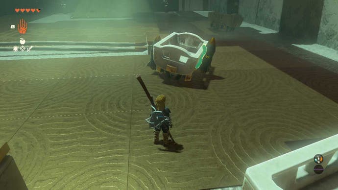Zelda Tears of the Kingdom, a cart in a Shrine with a rocket attached to either side of it. Link is looking at it.