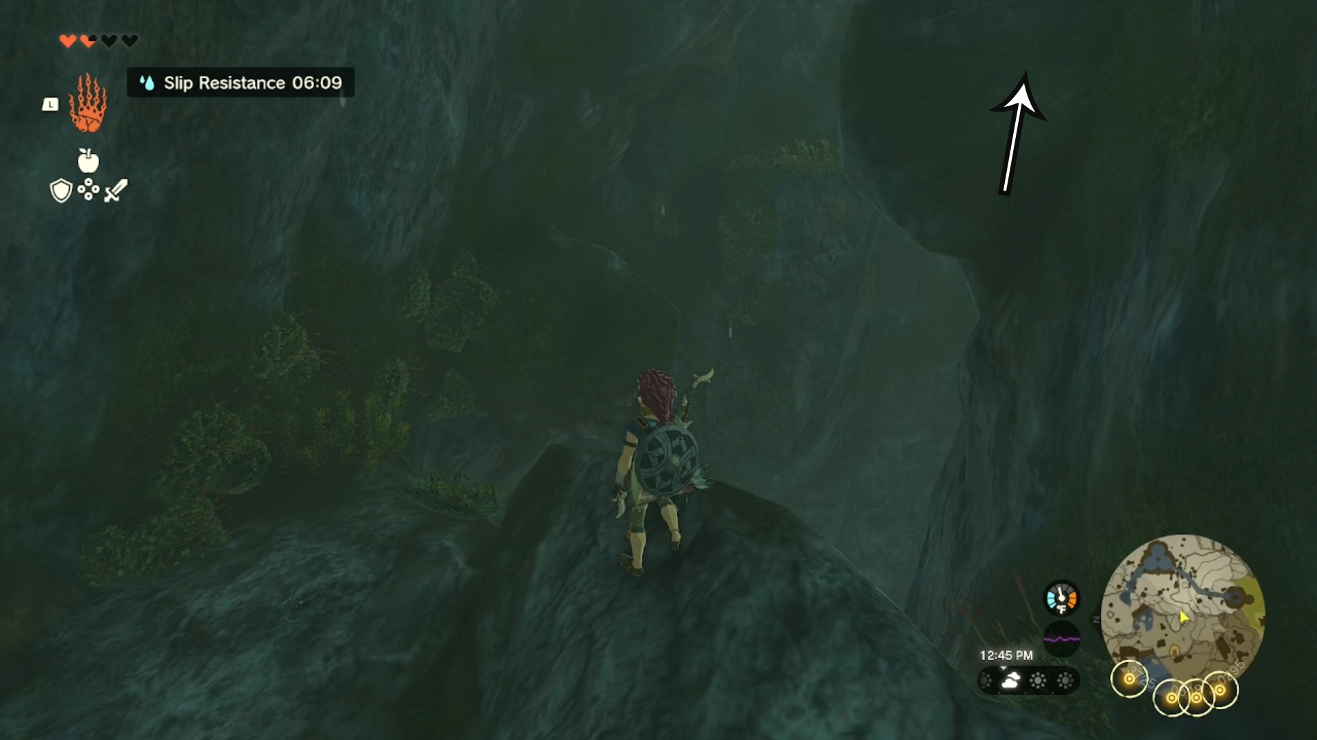 Link standing on a rock, with an arrow pointing in the direction players need to head in the Ploymous Mountain Cave.